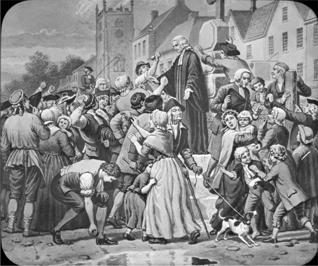 John Wesley, founder of the Wesleyan Church, preaching to a large, boisterous crowd